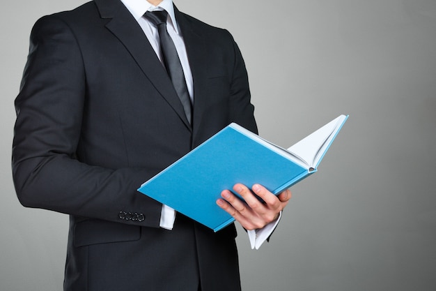 Unrecognizable businessman holding a book