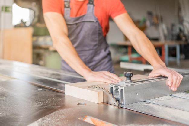 Unrecognizable carpenter working at sliding saw table