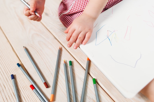 写真 カラフルな鉛筆で紙に描いている認識できない子供。