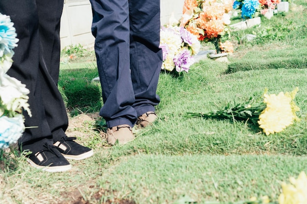Photo unrecognizable couple at cemetery visiting a relative commemorating their ancestors
