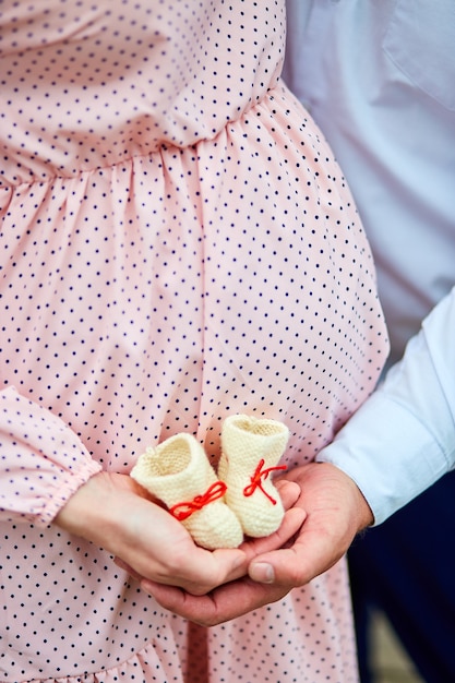 unrecognizable couple holding baby shoes