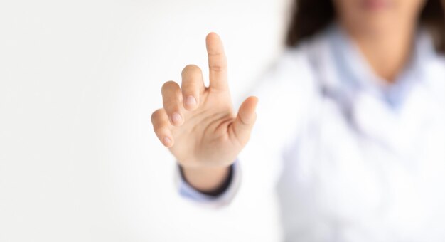 unrecognizable doctor woman pressing key on invisible medical touchscreen
