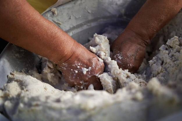 Foto una donna anziana irriconoscibile che prepara a mano le tortille di mais su una griglia nella sua modesta cucina di strada