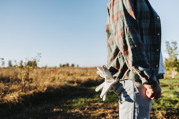 Неузнаваемый фермер с садовыми перчатками в заднем кармане Устойчивость сельского хозяйства