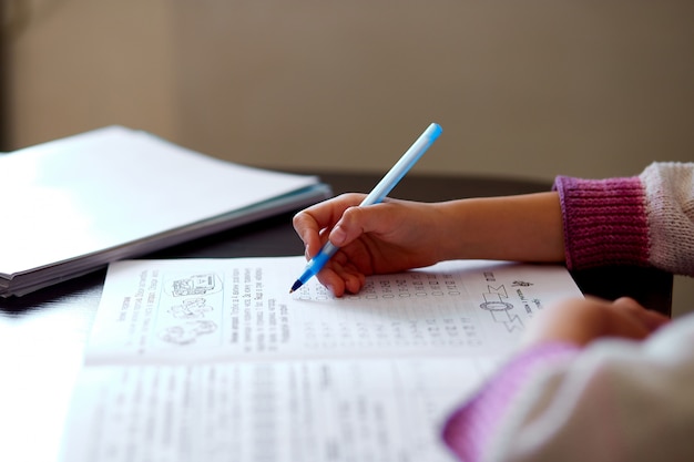 Photo unrecognizable girl doing homework, writing education concept, coronavirus home school  quarantine. a home schooler.