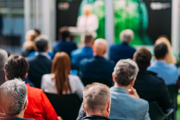 Gruppo irriconoscibile di persone sedute a un seminario o a una presentazione aziendale