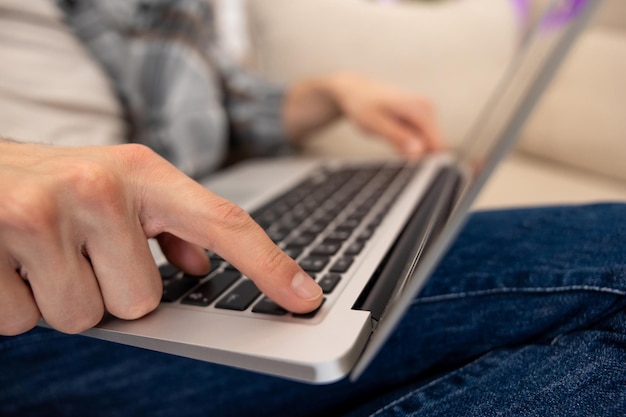 Unrecognizable guy using laptop working online pressing button typing keyboard