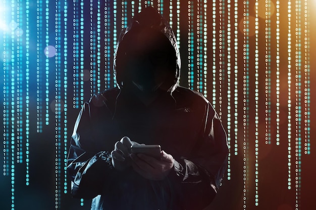 Неузнаваемый хакер, использующий портрет мобильного телефона, безопасность мобильного телефона и концепцию технологической преступности.