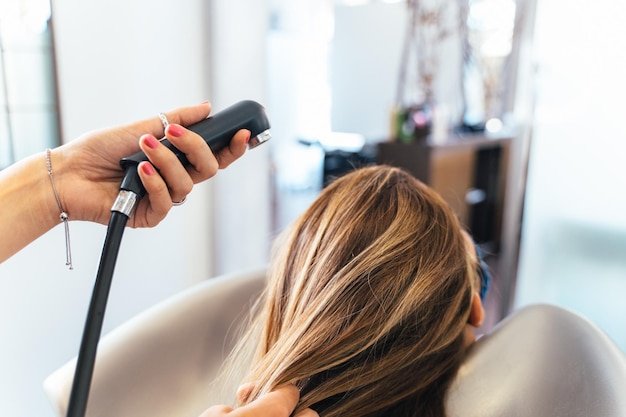 Unrecognizable Hairdresser washing the hair of a woman