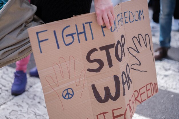 Unrecognizable hands carrying an antiwar banner Concept stop war peace demonstration