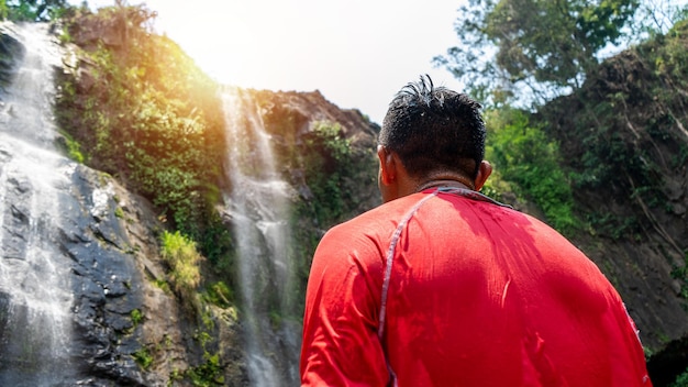 Фото Неузнаваемый латиноамериканец сзади стоит лицом к водопаду, который вот-вот поднимется.