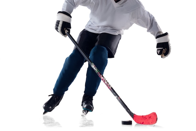 Unrecognizable male hockey player with the stick on ice court and white background