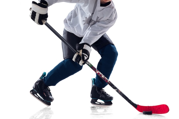 Unrecognizable male hockey player with the stick on ice court and white background