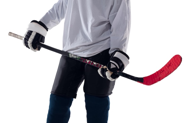 Unrecognizable male hockey player with the stick on ice court and white background