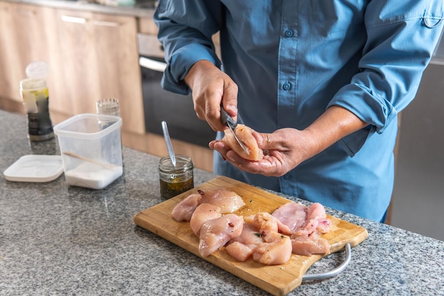 unrecognizable man cooking chicken in the kitchen