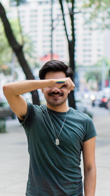 Unrecognizable man covering his eyes with his arm with rainbow makeup.