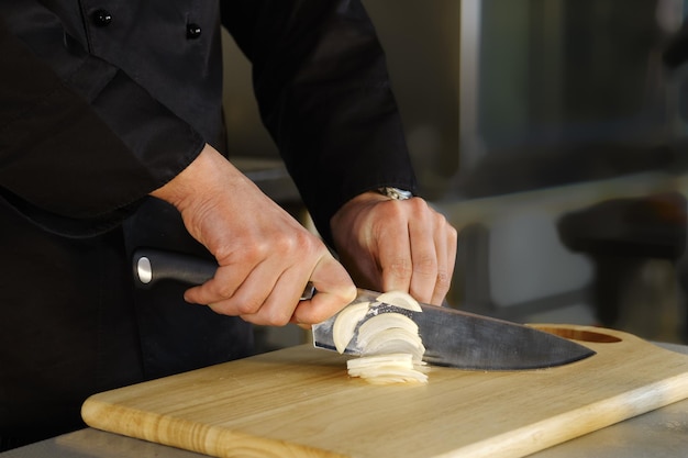 Unrecognizable man cuts onions