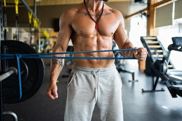 Unrecognizable man doing arm exercises using an elastic\
band