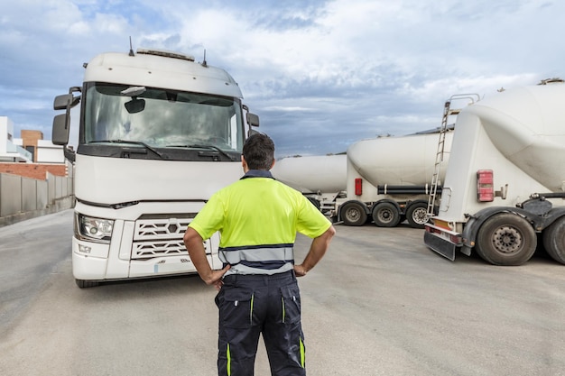 Unrecognizable man mechanic standing in front of parked truck in service center