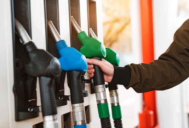 Uomo irriconoscibile che rifornisce di carburante l'auto dalla stazione di servizio che riempie il carburante della benzina della benzina in auto alla stazione di servizio concetto di prezzi elevati della benzina