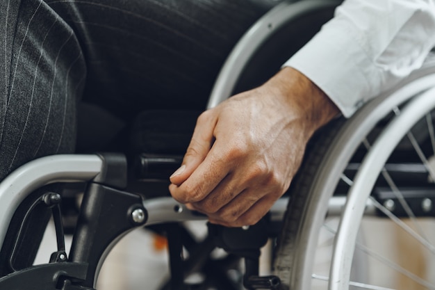 Unrecognizable man sitting in wheelchair close up