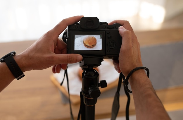 사진 디지털 카메라를 사용하여 햄버거 사진을 찍는 인식할 수 없는 남자