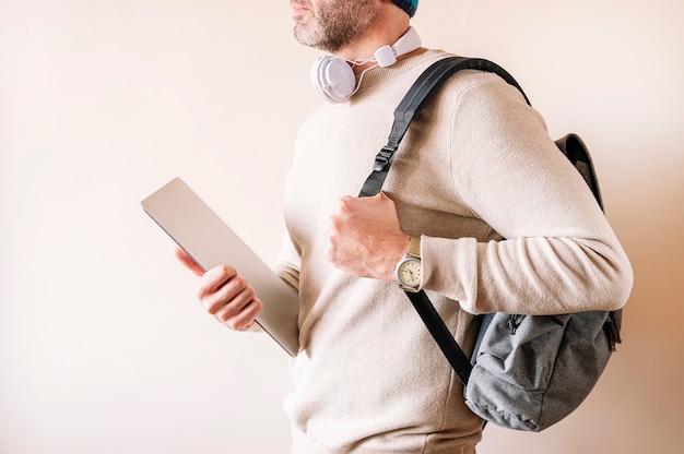 Unrecognizable man using laptop while standing.