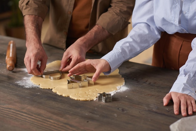 Unrecognizable man and woman spending time at home making tasty cookies copy space