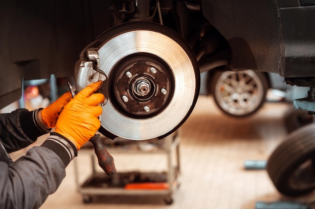 Unrecognizable man working on wheel brake pad