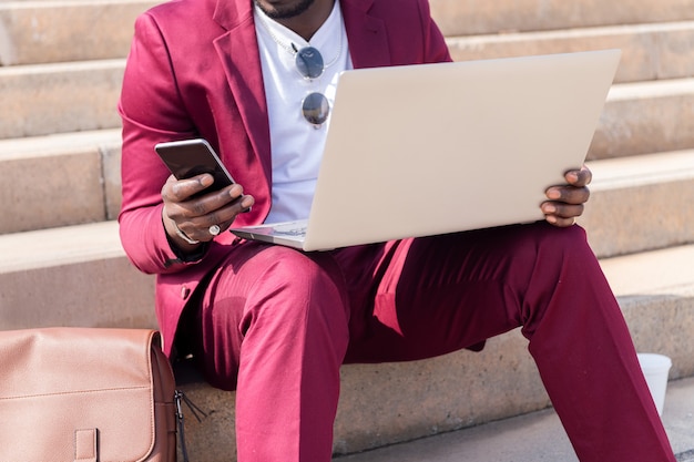 Unrecognizable man working with laptop and phone