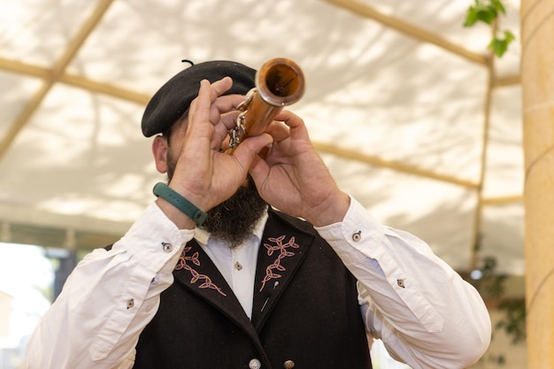 Unrecognizable musician in vintage costume playing bagpipes at an outdoor music folk festival Closeup selective focus