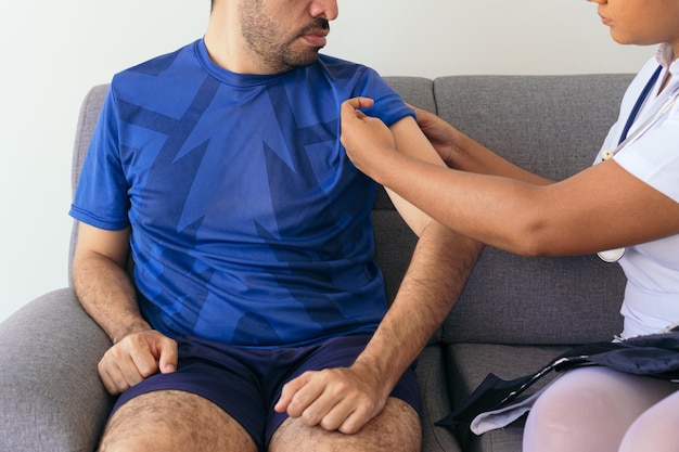 Unrecognizable nurse measuring a man39s blood pressure at home