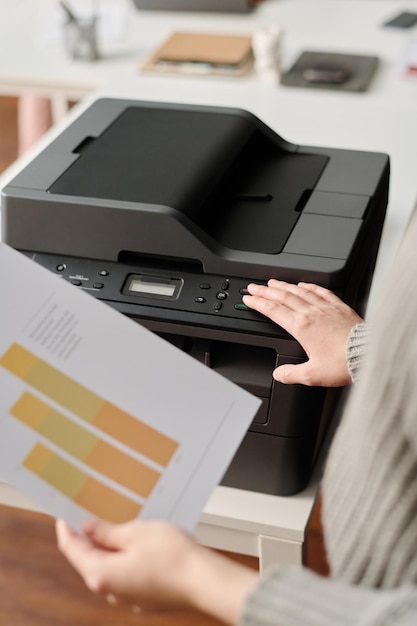 Photo unrecognizable office worker printing documents