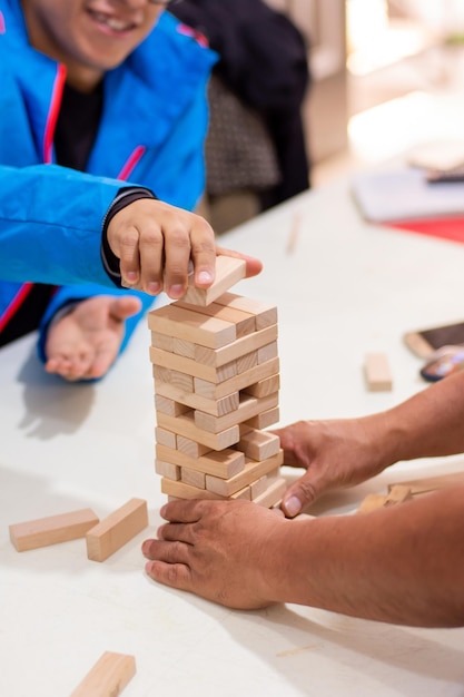 Unrecognizable people playing block game at home