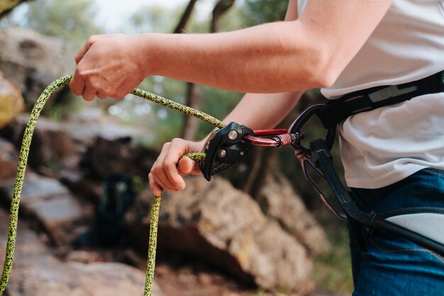 Photo unrecognizable person putting on the ropes for climbing. from above