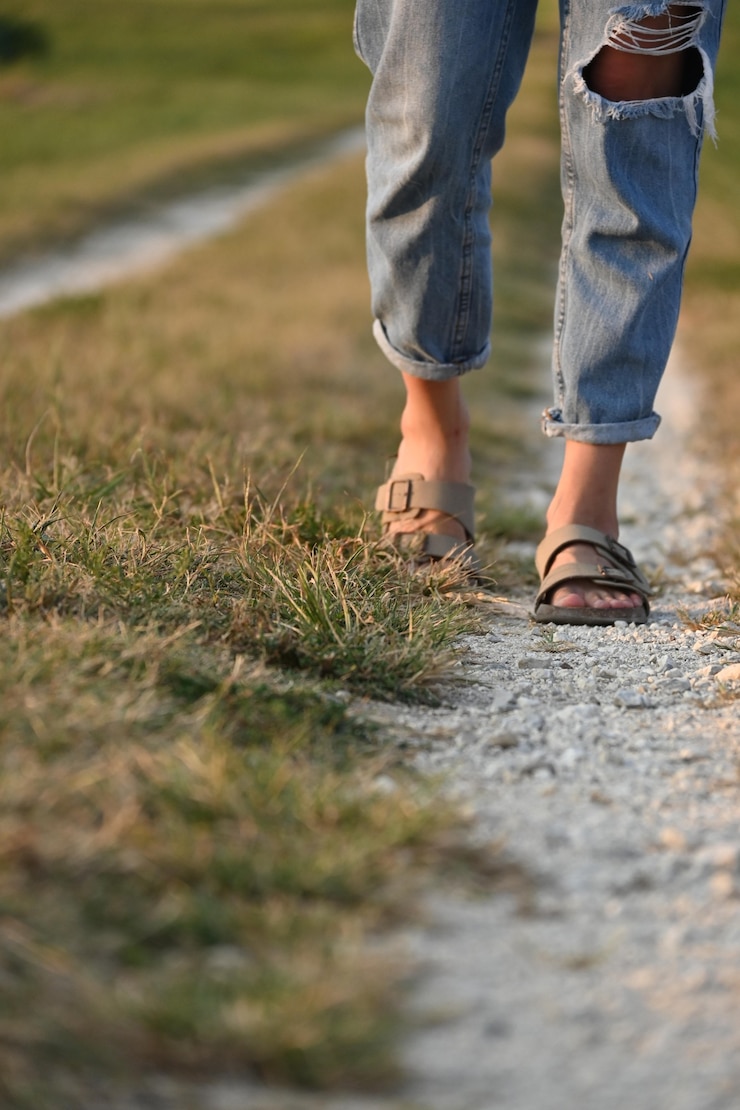 Unrecognizable person walking along country road