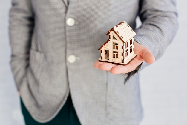 Photo unrecognizable realtor holding house figurine