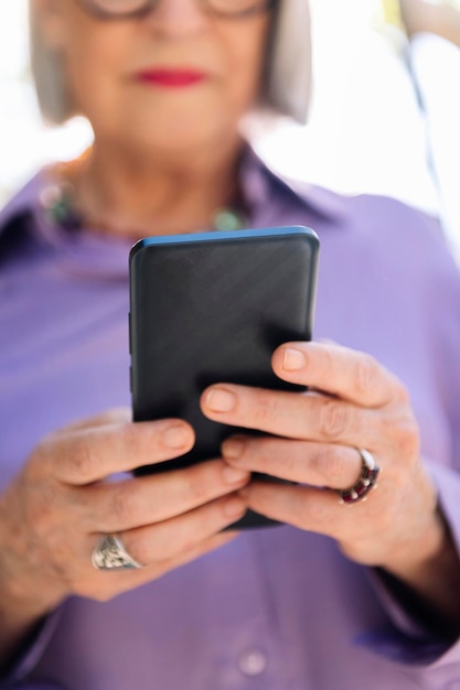 Unrecognizable senior woman using mobile phone