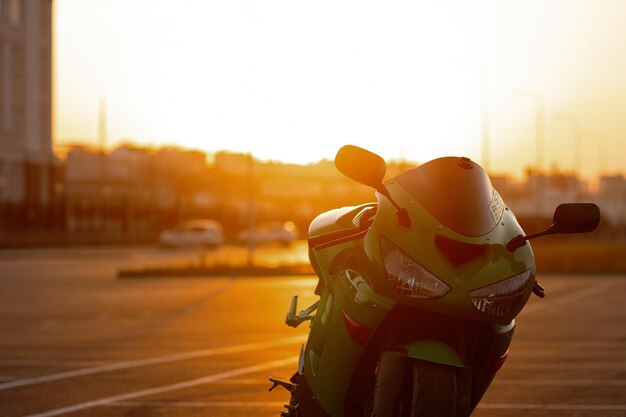 Unrecognizable stylish male motorcyclist in helmet sitting on parked motorbike in city