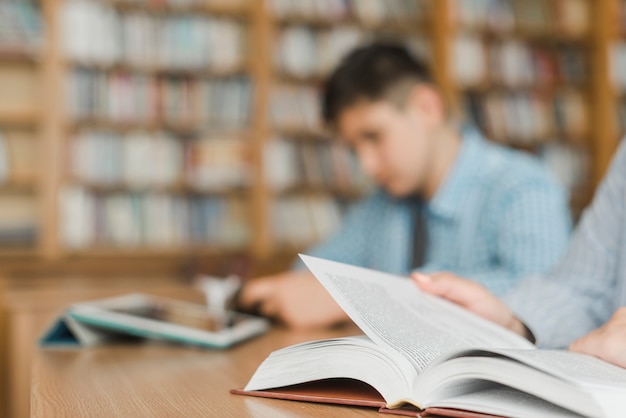 Unrecognizable teenagers studying in library