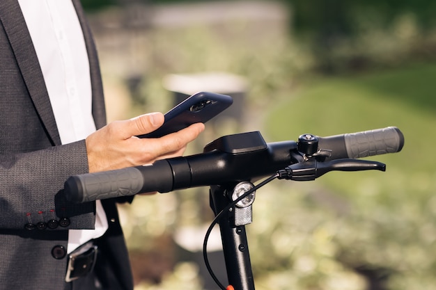 Unrecognizable tourist businessman take electric kick scooter nfc contactless locker man rents