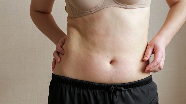 Unrecognizable woman feeling belly fat