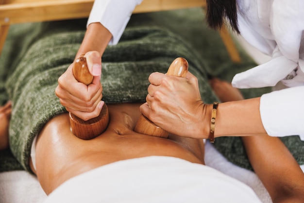 Photo an unrecognizable woman getting anti cellulite maderotherapy massage with wooden cup at the beauty salon.