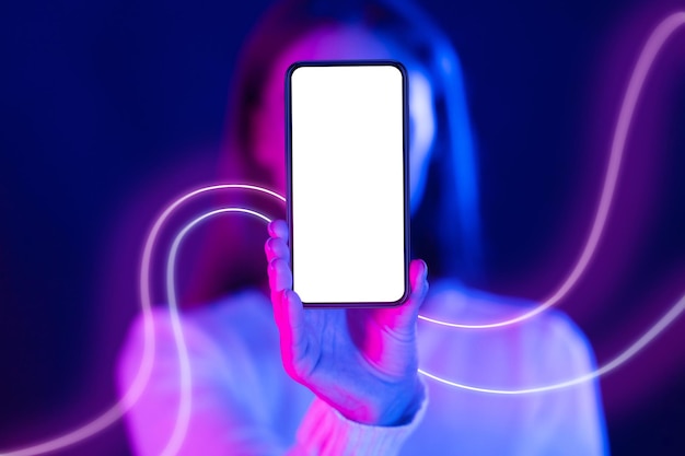 Unrecognizable woman hiding behind cell phone with blank screen mockup