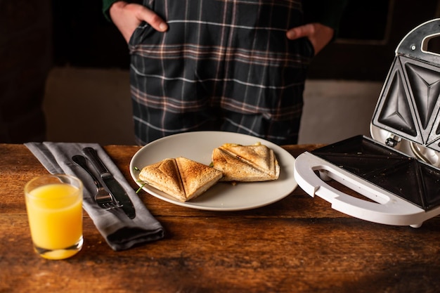 認識できない女性は、木製の背景にサンドイッチ トーストを食べるつもりです 朝の朝食スナック ダイエット