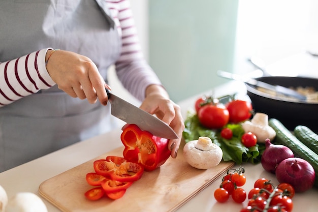 家で食事を準備する健康的な夕食を作る認識できない女性