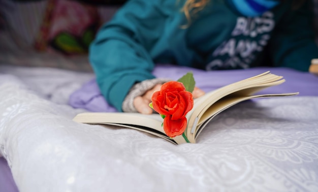 Unrecognizable woman reading a book with a rose Independence Day in Catalonia Sant George