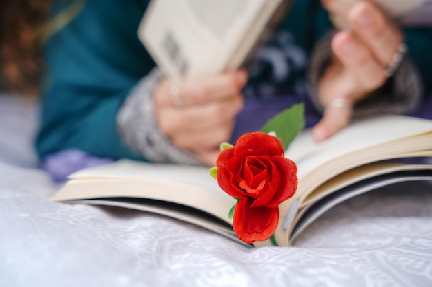 Unrecognizable woman reading a book with a rose Independence day of Catalonia Sant Jordi