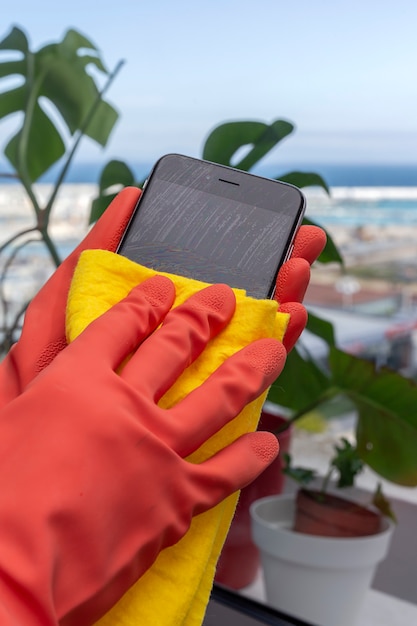 Unrecognizable woman's hands with protective gloves cleaning the house