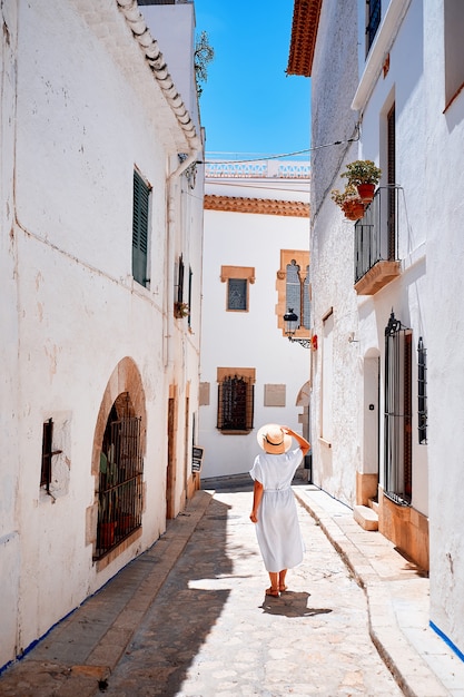 An unrecognizable woman summer trip. Back view of woman walks the narrow European streets. Outdoors shot.